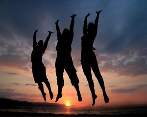 three people silhouettes jumping on the beach